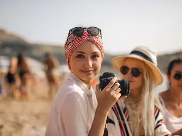 Friends enjoying a beach day with a camera
