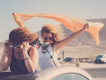 Friends enjoying a desert road trip in a convertible