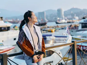 Traveler with a camera beside a sunny harbor